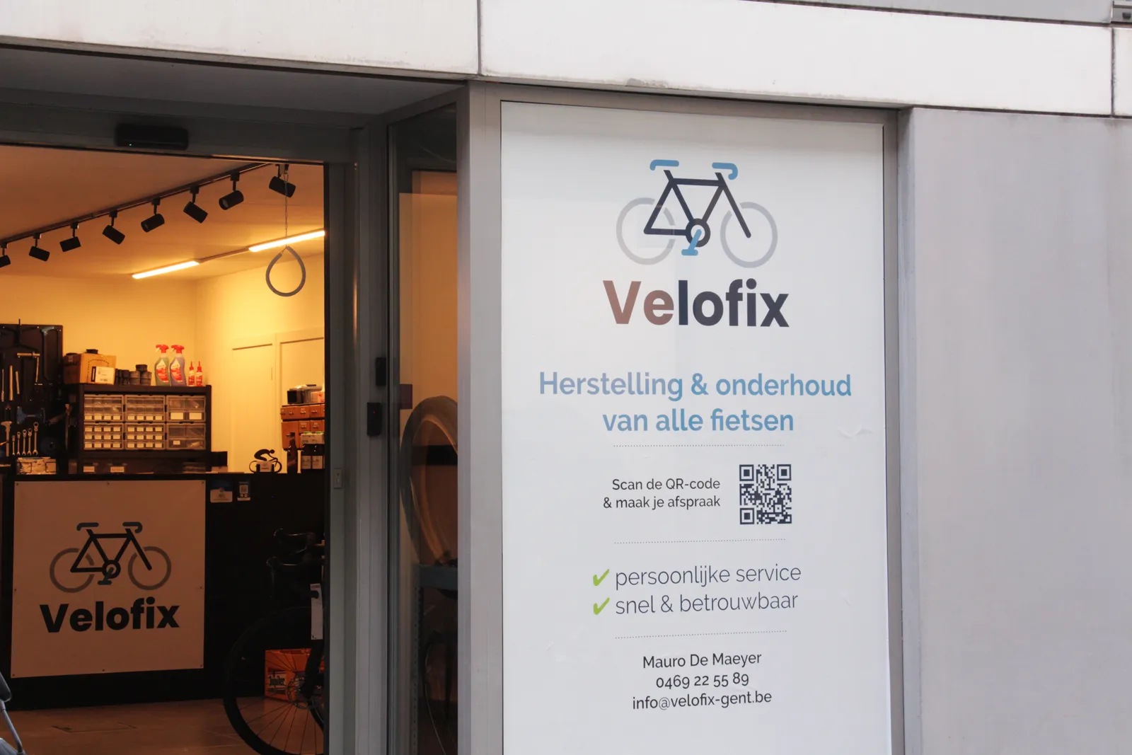 De winkelgevel van Velofix in Gent, met het uithangbord naast de open deur